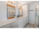 Stylish bathroom features dual sinks, wood-framed mirrors, and a glass-enclosed shower at 3938 Lake Joyce Dr, Land O Lakes, FL 34639