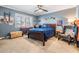 Cozy blue bedroom with ceiling fan, window with shutters, desk, and wood furnishings at 3938 Lake Joyce Dr, Land O Lakes, FL 34639