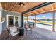 Relaxing covered patio with comfortable seating offers stunning views of the pool and lake at 3938 Lake Joyce Dr, Land O Lakes, FL 34639