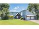 Inviting home exterior featuring a well-manicured lawn, beautiful landscaping, and a two-car garage at 3938 Lake Joyce Dr, Land O Lakes, FL 34639