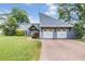 Home exterior featuring a well-manicured lawn, beautiful landscaping, and a two-car garage at 3938 Lake Joyce Dr, Land O Lakes, FL 34639