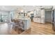 Bright kitchen features an island with seating, stainless appliances, and beautiful wood floors at 3938 Lake Joyce Dr, Land O Lakes, FL 34639