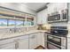 Close-up of a bright kitchen with stainless appliances and granite countertops with a view at 3938 Lake Joyce Dr, Land O Lakes, FL 34639