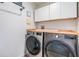Contemporary laundry area featuring new front-load washer and dryer, plus overhead storage at 3938 Lake Joyce Dr, Land O Lakes, FL 34639