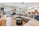 Bright living room featuring a fireplace, hardwood floors, and large windows overlooking the backyard at 3938 Lake Joyce Dr, Land O Lakes, FL 34639
