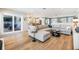 Spacious living room with hardwood floors, modern furniture, and an open layout connecting to the kitchen at 3938 Lake Joyce Dr, Land O Lakes, FL 34639