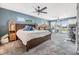 Serene main bedroom with blue walls, large windows, and water views at 3938 Lake Joyce Dr, Land O Lakes, FL 34639