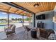 Covered outdoor patio area with brick flooring, comfortable seating, and a view of the water at 3938 Lake Joyce Dr, Land O Lakes, FL 34639