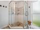 Detailed view of a glass-enclosed shower with stone flooring and subway tile at 3938 Lake Joyce Dr, Land O Lakes, FL 34639