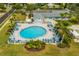 Aerial shot displays a community pool surrounded by palm trees and equipped with lounge chairs and umbrellas at 4017 103Rd N Ave, Clearwater, FL 33762