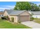 Side view of home with lush green grass and light tan exterior, showing the driveway at 4017 103Rd N Ave, Clearwater, FL 33762
