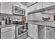 Updated kitchen with modern stainless appliances, white cabinets, and bar pass-through at 4017 103Rd N Ave, Clearwater, FL 33762