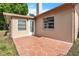 View of the rear patio and the back of the house with a door and multiple windows at 4017 103Rd N Ave, Clearwater, FL 33762