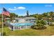 Aerial view of the community pool area, surrounded by palm trees, lush lawns, and cozy seating spots at 4017 103Rd N Ave, Clearwater, FL 33762