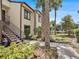 The condo's exterior with lush, tropical landscaping and a walkway leading to a waterfront view at 404 Moorings Cove Dr # 404, Tarpon Springs, FL 34689