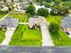 Beautiful aerial view of a landscaped home with a large lawn, long driveway, and a view of the lake at 4615 Cozzo Dr, Land O Lakes, FL 34639