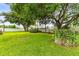 Well-manicured backyard with lush green grass, beautiful trees, and flowerbeds for relaxation at 4615 Cozzo Dr, Land O Lakes, FL 34639