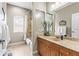 Bright bathroom featuring a shower with a tiled wall and wooden vanity at 4615 Cozzo Dr, Land O Lakes, FL 34639