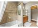 Bright bathroom featuring a shower with a tiled wall and neutral vanity at 4615 Cozzo Dr, Land O Lakes, FL 34639