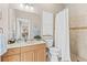 Bathroom with a single sink vanity, commode and tiled walk-in shower with glass door at 4615 Cozzo Dr, Land O Lakes, FL 34639