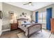 Bright bedroom featuring a wood bed frame, ceiling fan and an en suite bathroom at 4615 Cozzo Dr, Land O Lakes, FL 34639