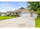Charming single-story home boasting a three-car garage, lush landscaping, and a manicured lawn at 4615 Cozzo Dr, Land O Lakes, FL 34639