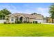 Single-story home with a well-maintained lawn, lush landscaping, and a convenient three-car garage at 4615 Cozzo Dr, Land O Lakes, FL 34639