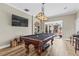 Game room with pool table, large TV, and sliding glass doors to the outdoor space at 4615 Cozzo Dr, Land O Lakes, FL 34639