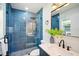 Modern bathroom featuring blue tiled walls, a glass shower, and a sleek vanity with stylish fixtures at 5030 9Th S Ave, Gulfport, FL 33707
