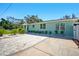 Single-story home with a spacious paved driveway, complemented by green landscaping and a freshly painted facade at 5030 9Th S Ave, Gulfport, FL 33707