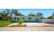 Charming single-story home with a light green exterior, complemented by a well-manicured lawn and landscaped garden at 5030 9Th S Ave, Gulfport, FL 33707
