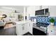 Modern kitchen with stainless steel appliances, white cabinets, and beautiful backsplash opens to the living room at 5030 9Th S Ave, Gulfport, FL 33707
