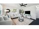 Elegant living room with modern furnishings, a decorative ceiling fan, and plenty of natural light from the window at 5030 9Th S Ave, Gulfport, FL 33707