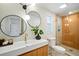 Updated bathroom with modern fixtures, including a glass-enclosed shower, modern sink, and circular mirrors at 5647 110Th Way, Seminole, FL 33772