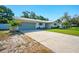 Inviting exterior with green garage door, well-maintained landscaping, and long driveway at 5647 110Th Way, Seminole, FL 33772