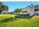 Beautifully landscaped front yard with green grass, palm trees and mature landscaping at 5647 110Th Way, Seminole, FL 33772