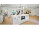 Bright and open kitchen with island, stone countertops, built-in microwave and views into dining area at 5647 110Th Way, Seminole, FL 33772