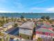 Stunning aerial view of homes near a picturesque beach with sailboats on the water and palm tree lined street at 5659-5657 Shore S Blvd, Gulfport, FL 33707