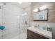 Modern bathroom featuring a glass shower and wood-accented vanity at 5659-5657 Shore S Blvd, Gulfport, FL 33707