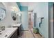 Charming bathroom with dual sinks and step-in shower featuring blue walls at 5659-5657 Shore S Blvd, Gulfport, FL 33707