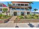 Stunning three-story home with lush landscaping, gated entry, and inviting outdoor living spaces at 5659-5657 Shore S Blvd, Gulfport, FL 33707