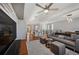 Bright open-concept living room featuring hardwood floors, a modern ceiling fan, and comfortable seating at 5659-5657 Shore S Blvd, Gulfport, FL 33707