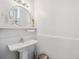 Bright powder room with a pedestal sink, modern mirror, and clean, minimalist design at 5659-5657 Shore S Blvd, Gulfport, FL 33707