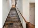 Slate tile staircase featuring a wood handrail and white walls, leading up to the next level at 5659-5657 Shore S Blvd, Gulfport, FL 33707