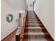 Traditional stairway with decorative wreaths, wooden banister and carpet runner on the stairs at 5659-5657 Shore S Blvd, Gulfport, FL 33707