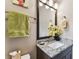 Granite top bathroom vanity and a mirror with yellow flower decorations at 6022 S Elkins Ave, Tampa, FL 33611