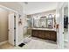 Modern bathroom with double vanity, glass enclosed shower, and a walk-in closet at 6022 S Elkins Ave, Tampa, FL 33611