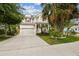 Two-story home with a covered porch, lush landscaping, an American flag, and an attached two-car garage at 6022 S Elkins Ave, Tampa, FL 33611