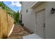Exterior side view of a home with a walkway featuring stone pavers and a backyard access door at 6022 S Elkins Ave, Tampa, FL 33611