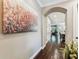 Hallway featuring hardwood floors, arched doorways, a large art piece, and natural light at 6022 S Elkins Ave, Tampa, FL 33611